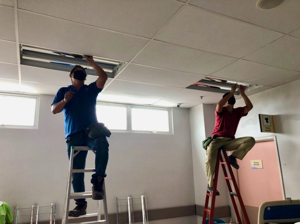 2 letrik union technician climbing ladder installing light